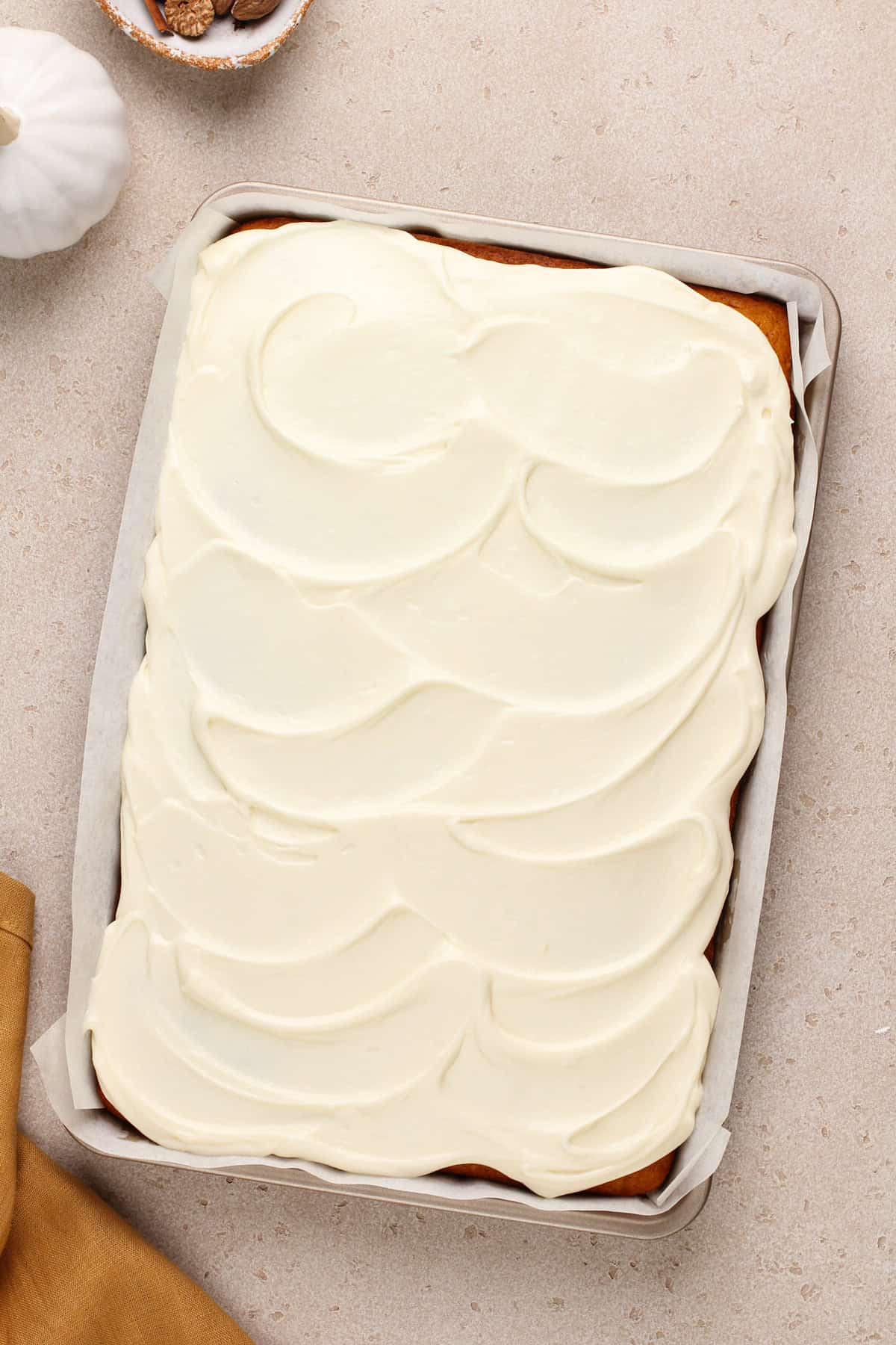 Pumpkin bars in a jelly roll pan topped with cream cheese frosting.