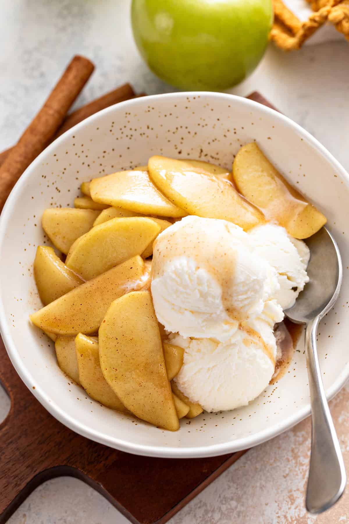 Vanilla ice cream and sauteed apples in a bowl.