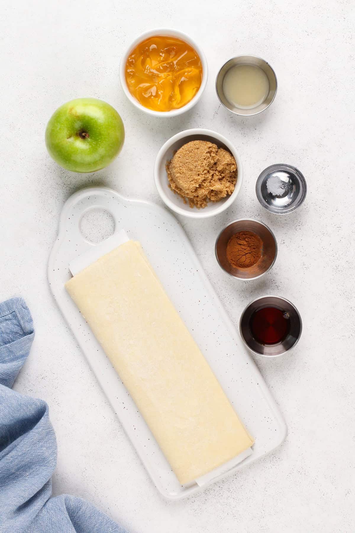 Ingredients for puff pastry apple tart on a countertop.