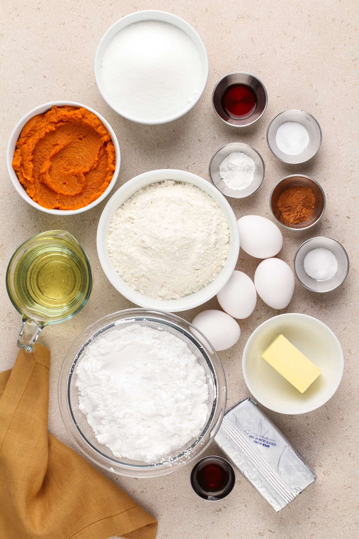 Ingredients for pumpkin bars with cream cheese frosting arranged on a countertop.