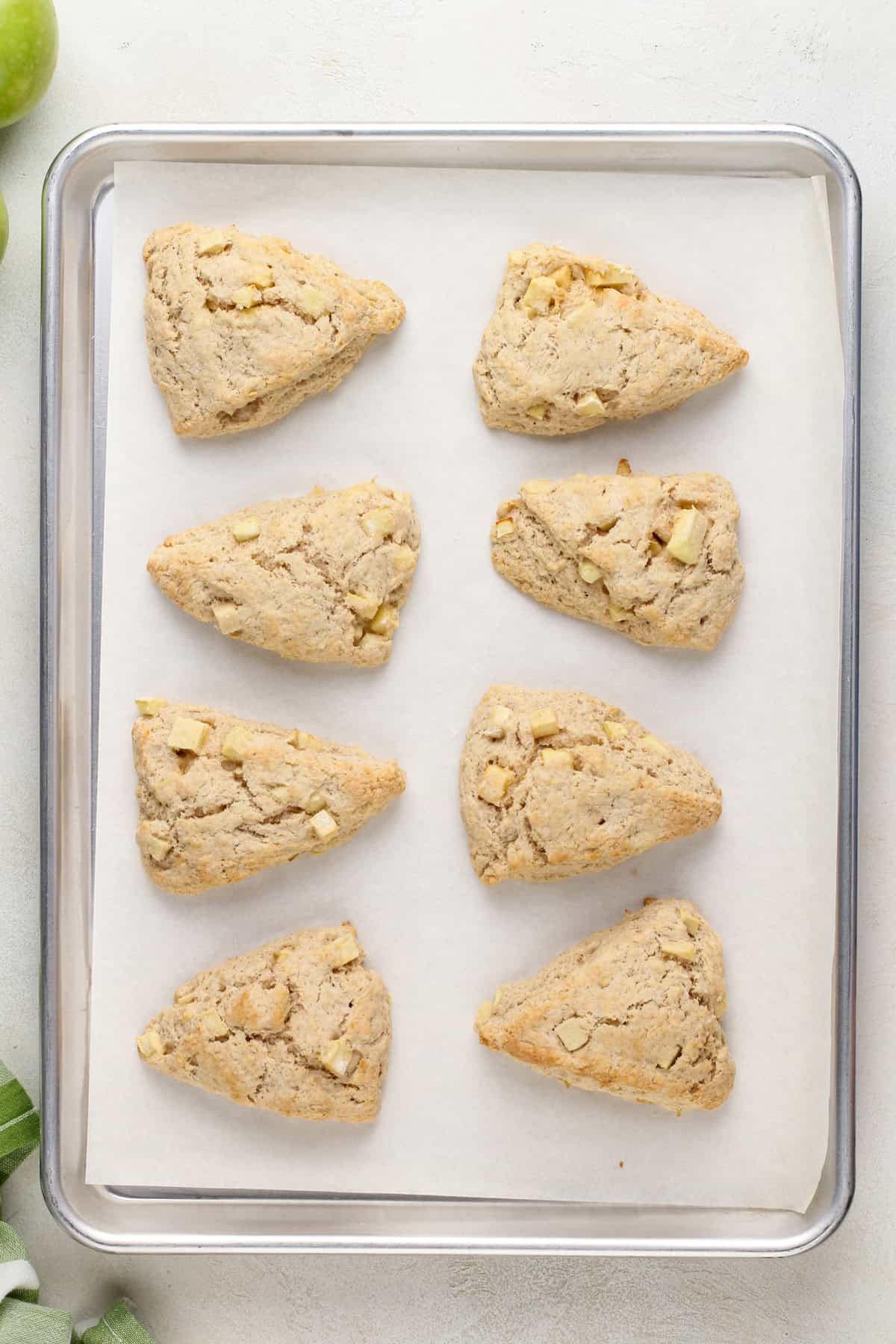 Baked apple scones on a lined baking sheet.