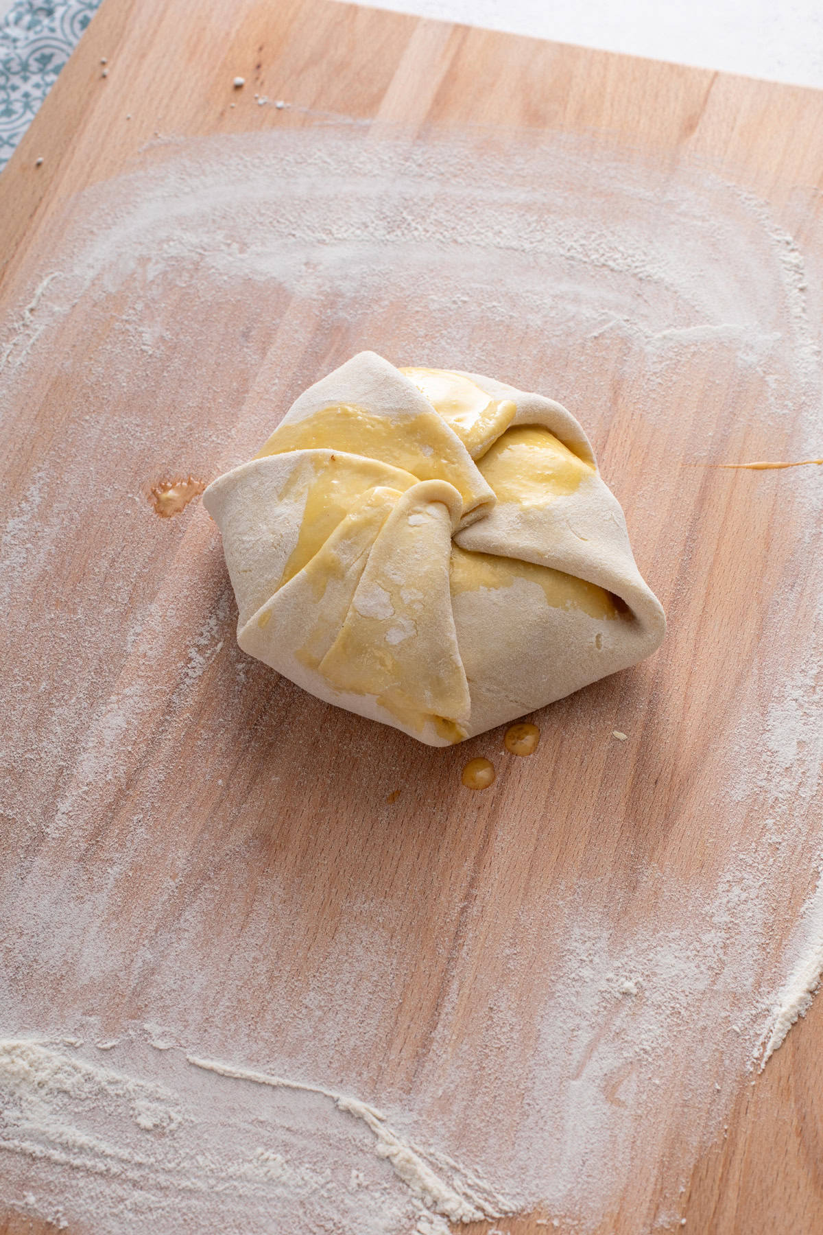 Brie wrapped in puff pastry on a wooden board.