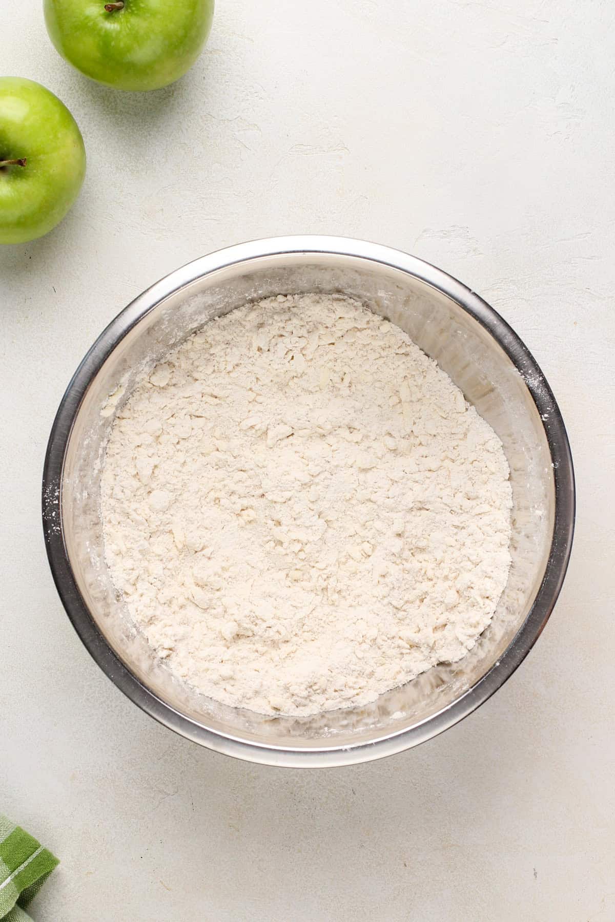 Butter mixed into flour in a metal bowl.