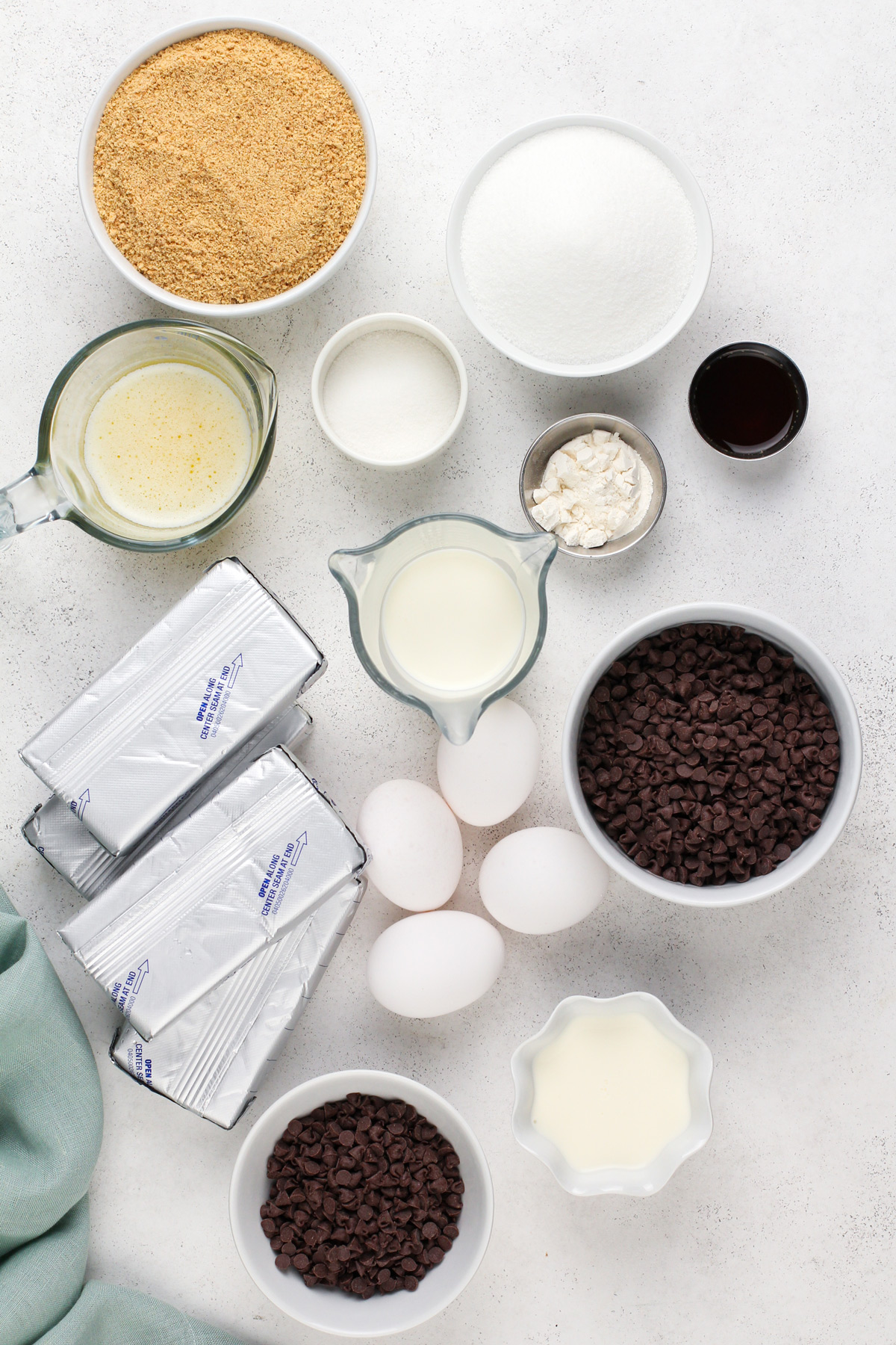 Ingredients for chocolate chip cheesecake arranged on a countertop.