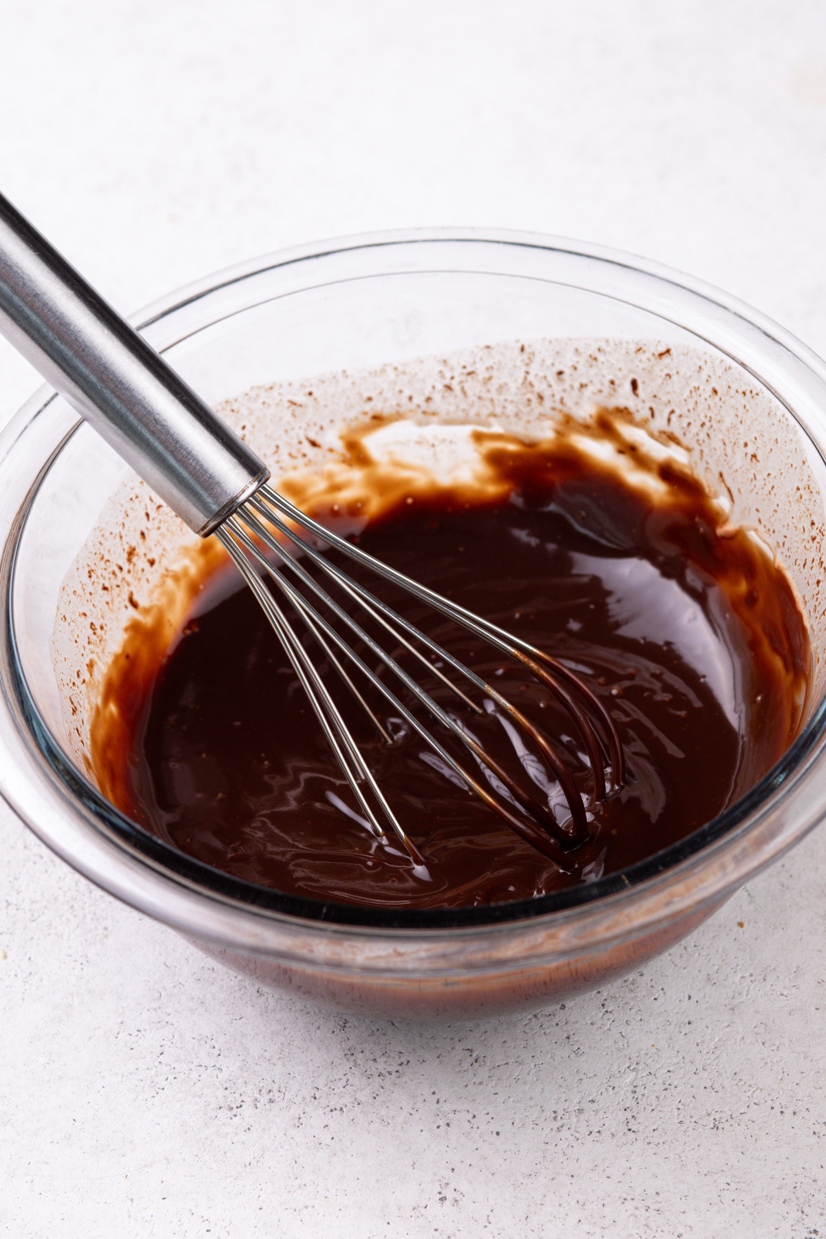 Chocolate ganache in a glass mixing bowl.