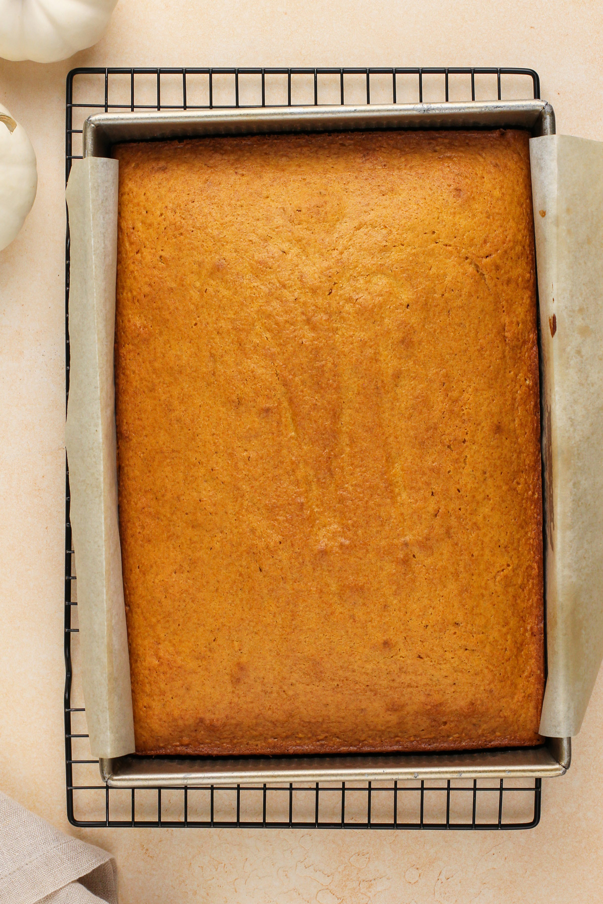 Baked pumpkin cake cooling on a wire rack.