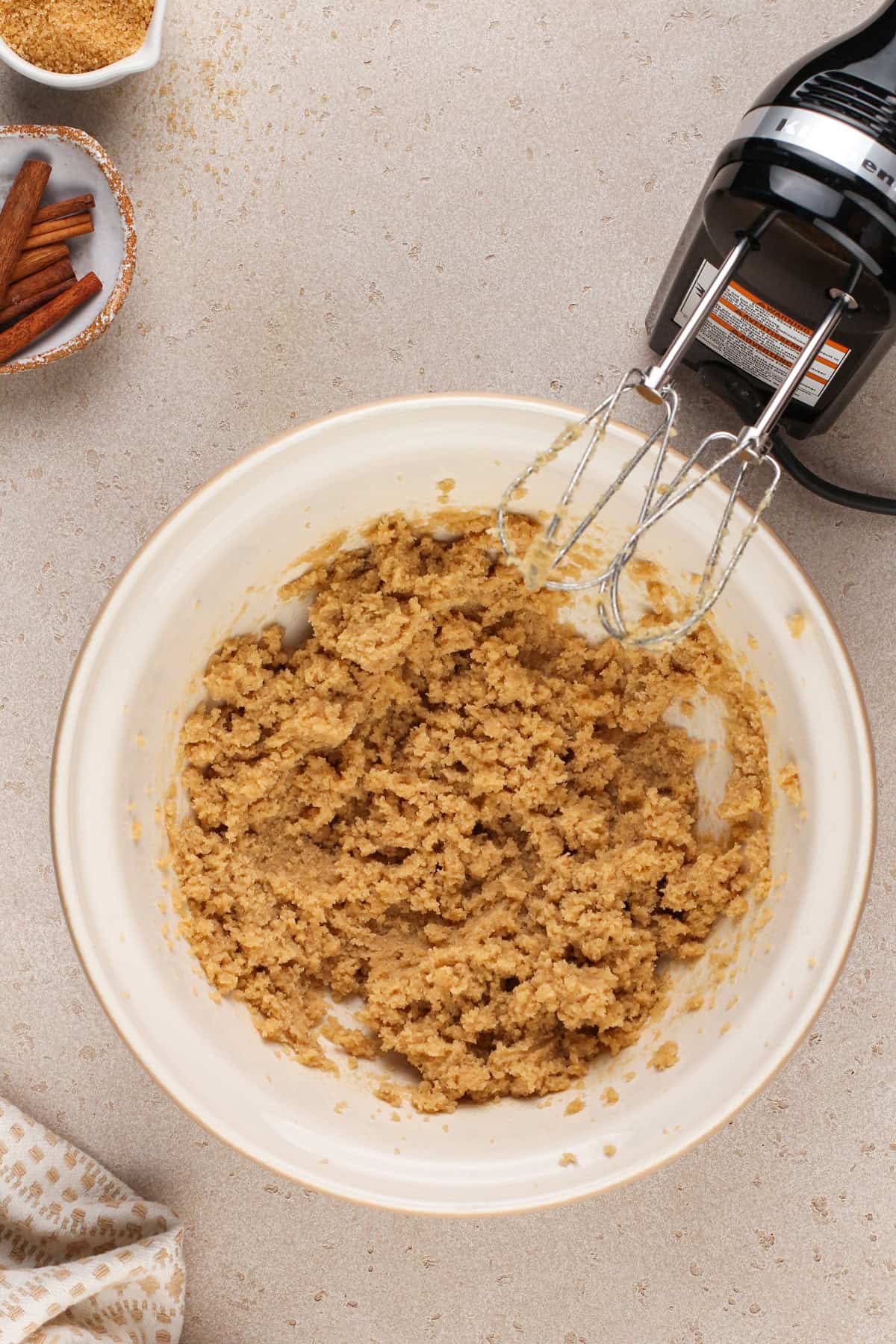 Butter and brown sugar creamed together in a ceramic mixing bowl.