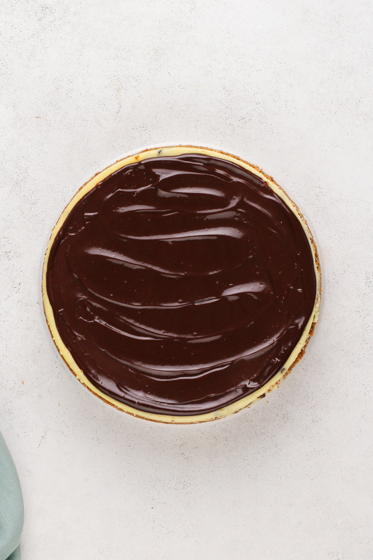 Chocolate ganache spread over cooled chocolate chip cheesecake.