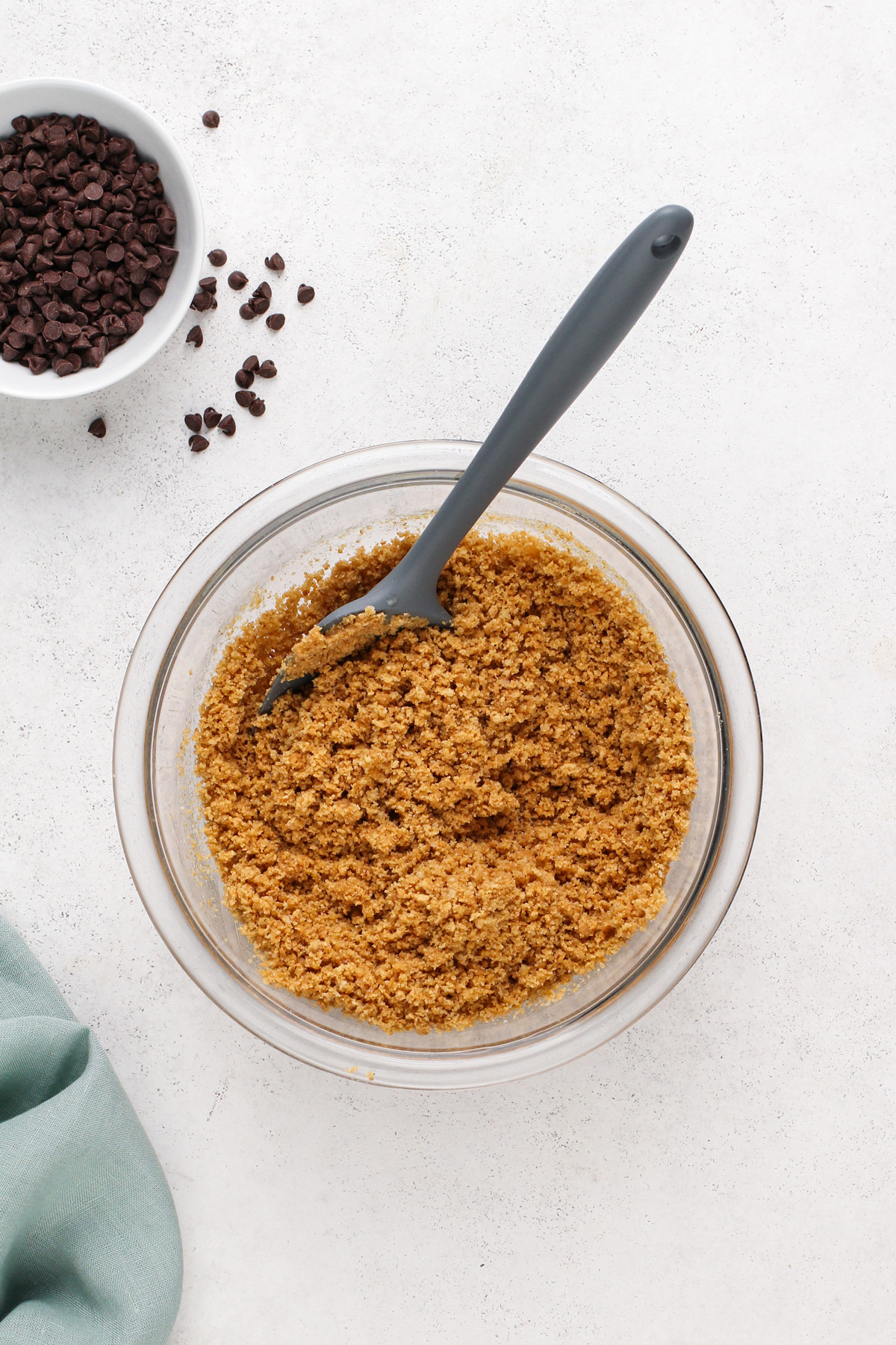 Graham cracker crust mixture in a glass bowl.