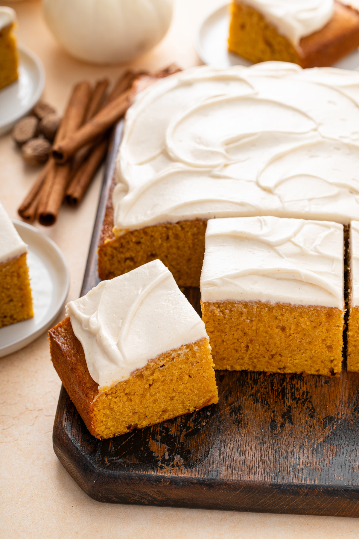 Slices of pumpkin sheet cake on a serving board.