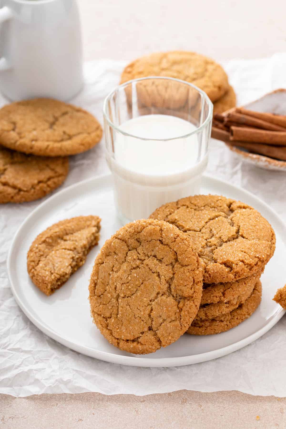 Brown sugar cinnamon cookies on a white plate next to a glass of milk.