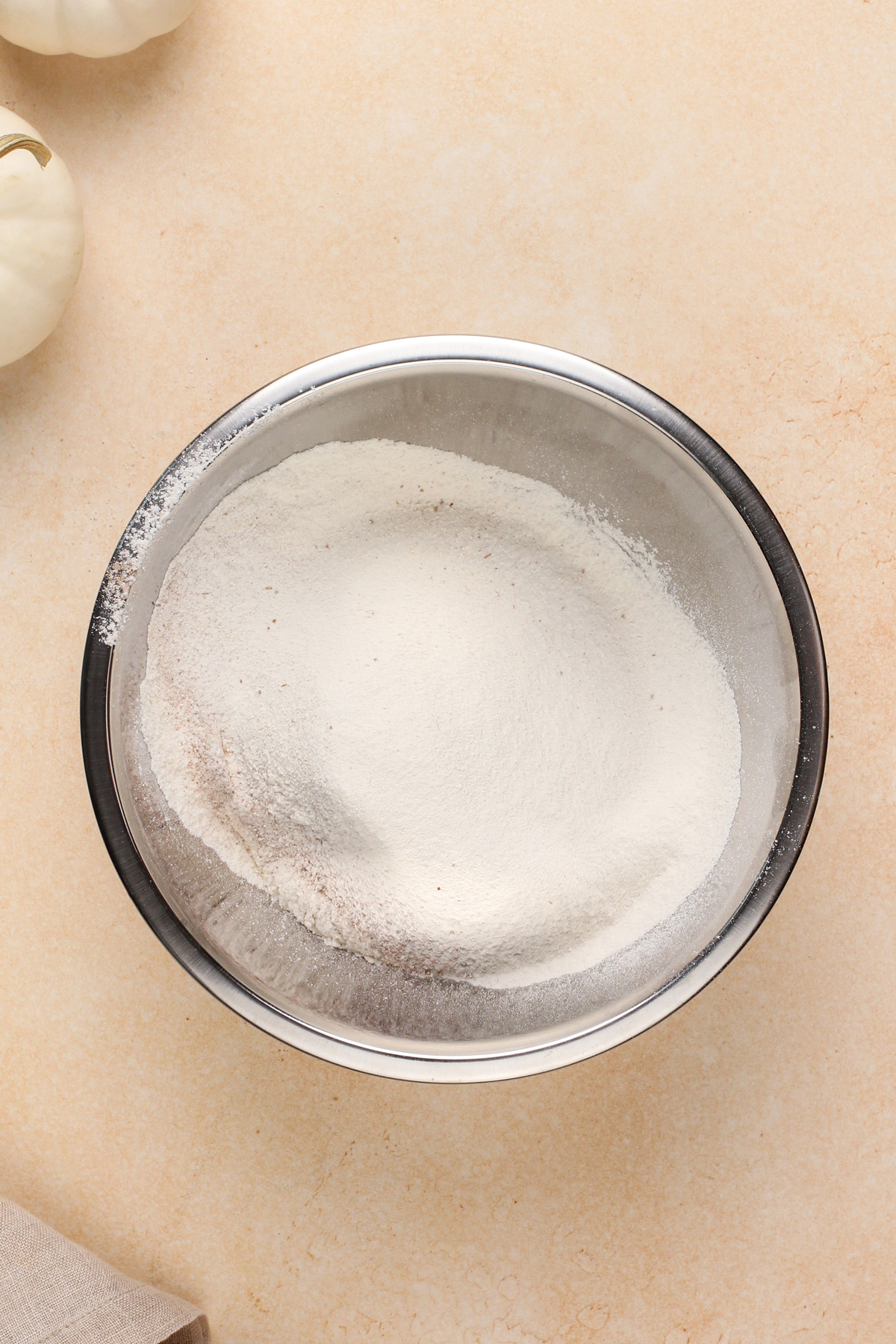 Dry ingredients for pumpkin cake in a metal bowl.