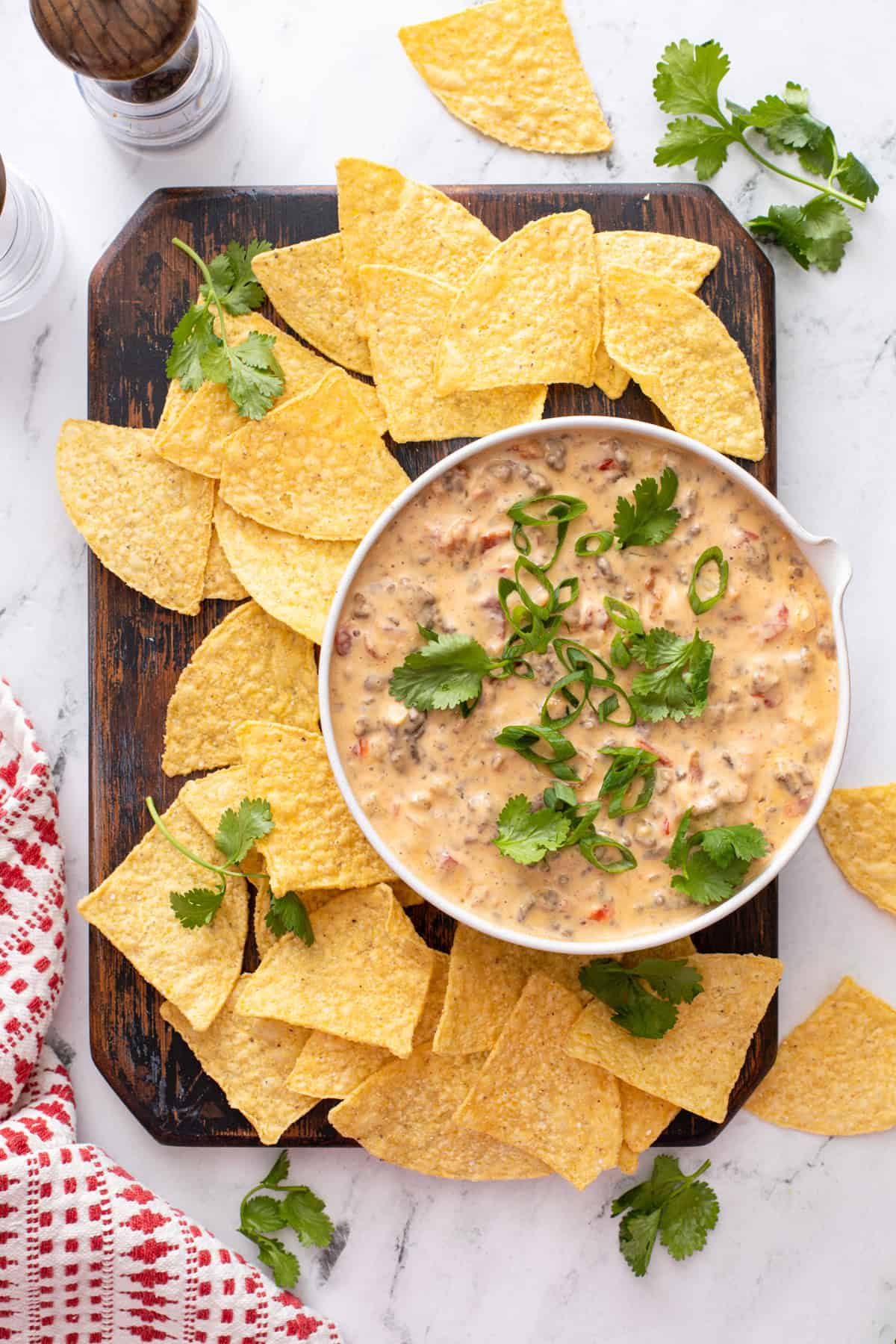 Overhead view of a bowl of rotel dip on a platter of tortilla chips.