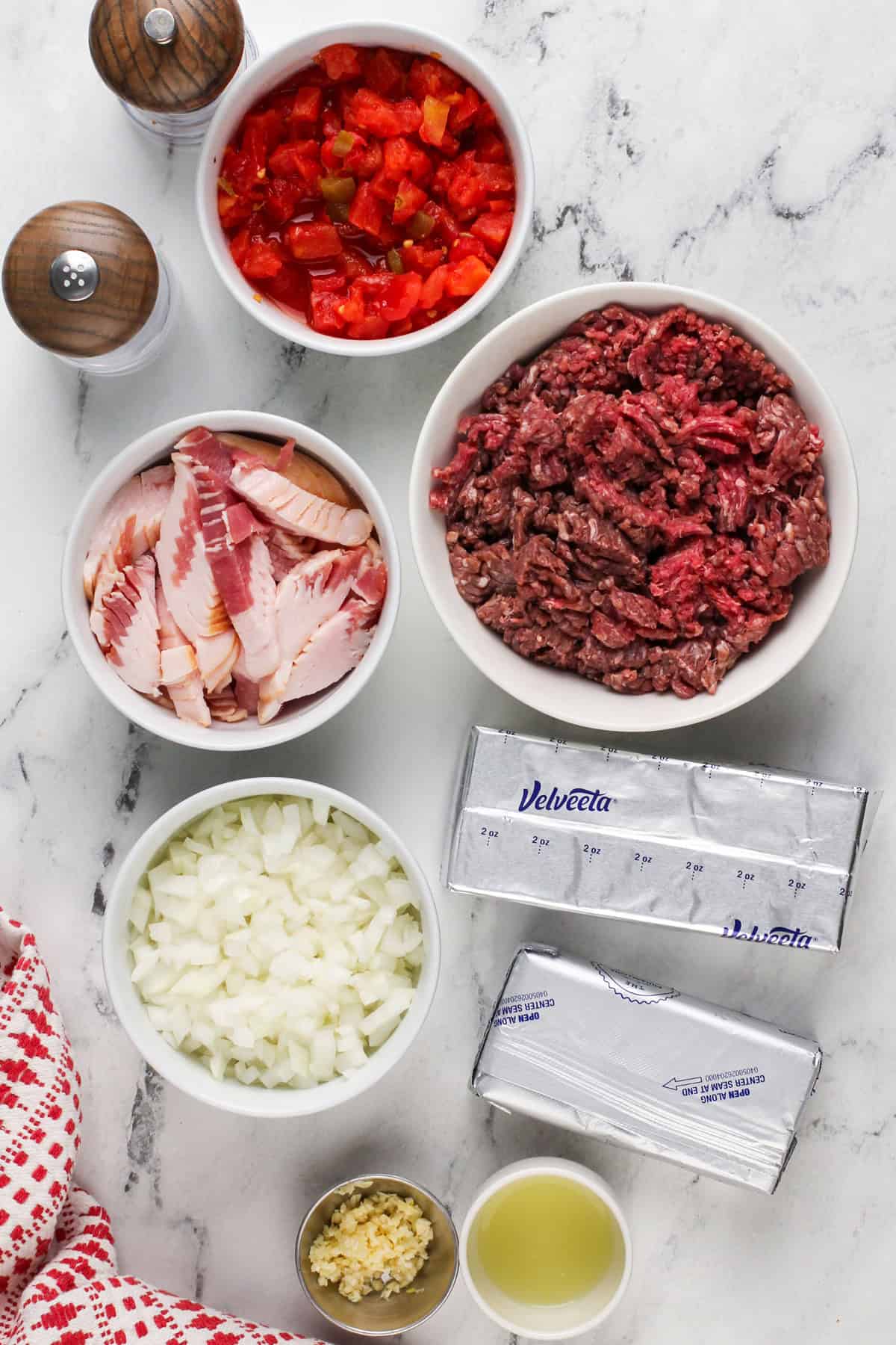 Ingredients for rotel dip arranged on a marble countertop.