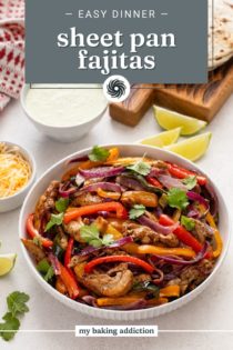 Bowl of sheet pan chicken fajitas on a countertop surrounded by fajita toppings. Text overlay includes recipe name.