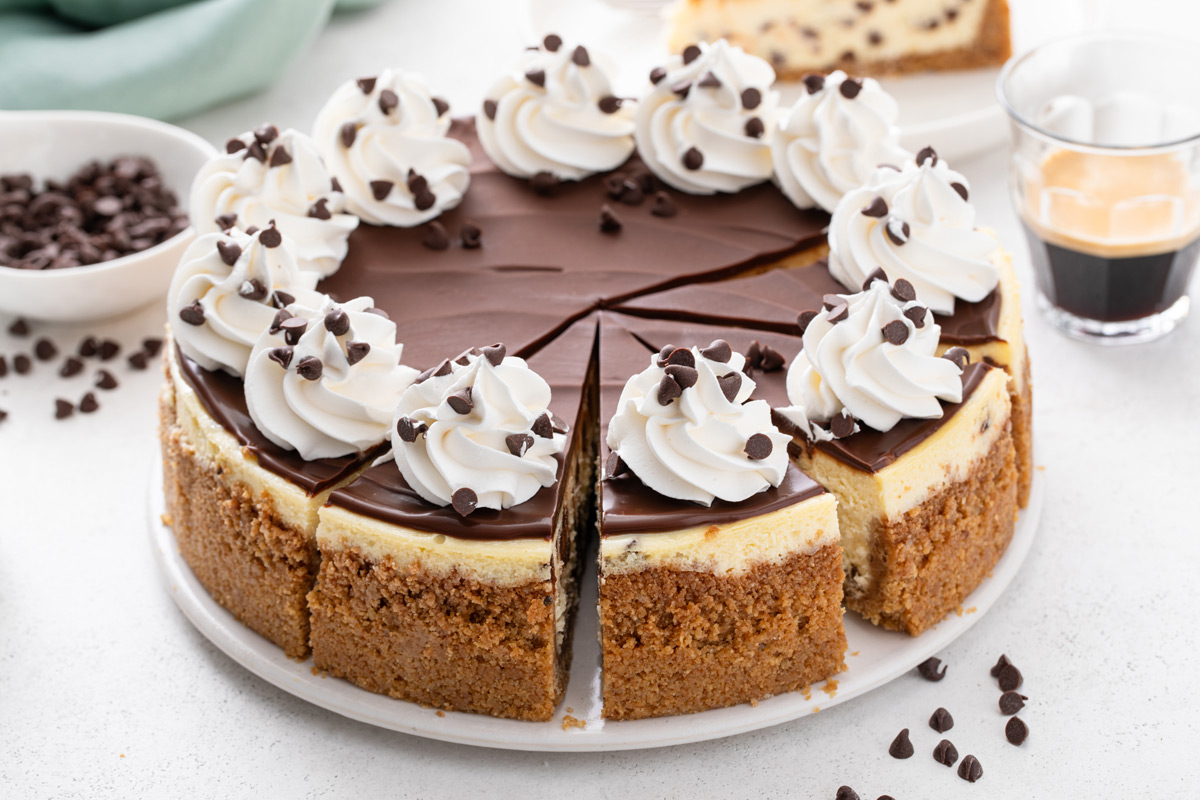 Sliced chocolate chip cheesecake garnished with whipped cream.