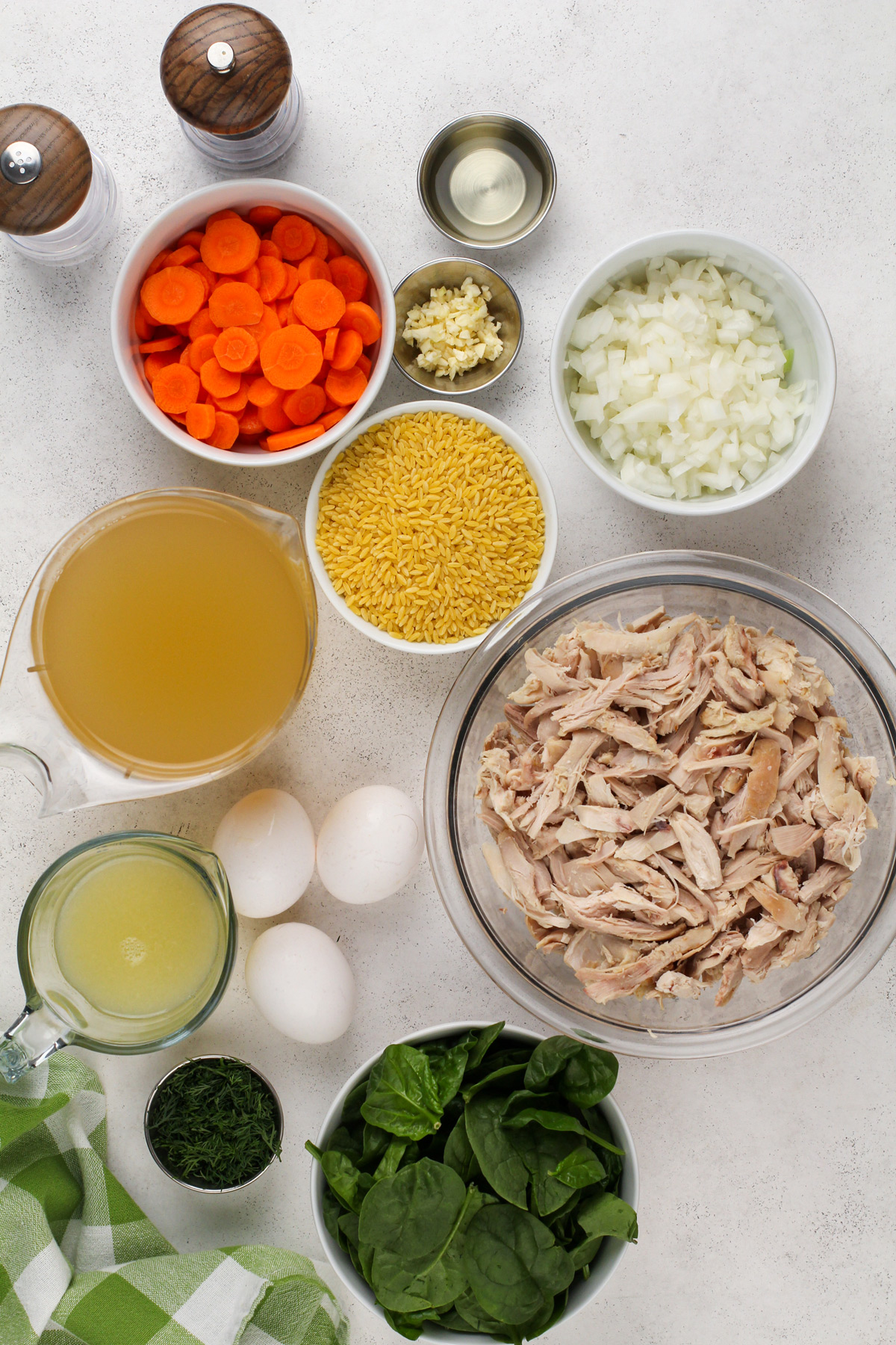 Ingredients for lemon chicken orzo soup arranged on a countertop.