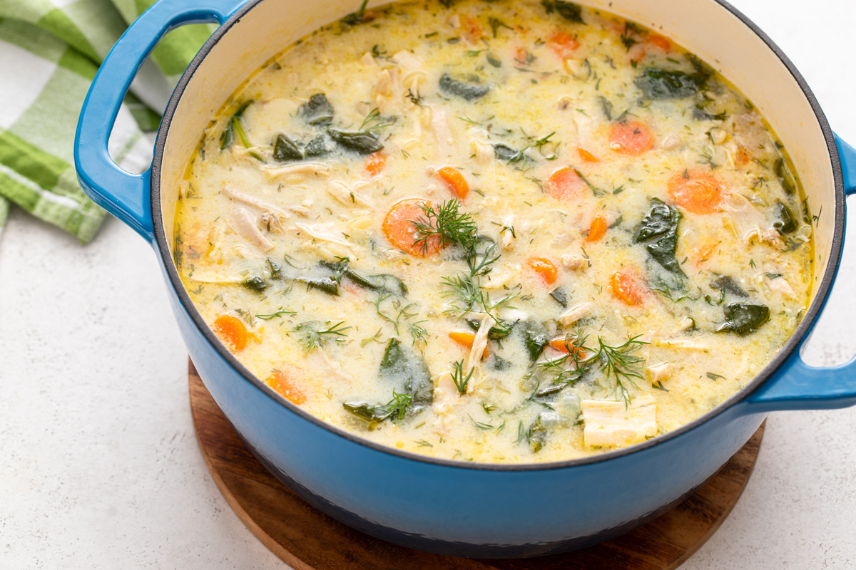 Blue dutch oven filled with lemon chicken orzo soup.