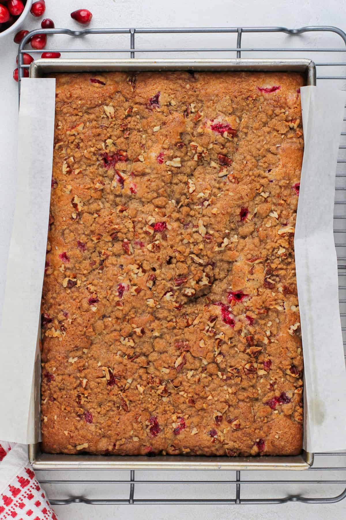 Baked cranberry cake cooling on a wire rack.