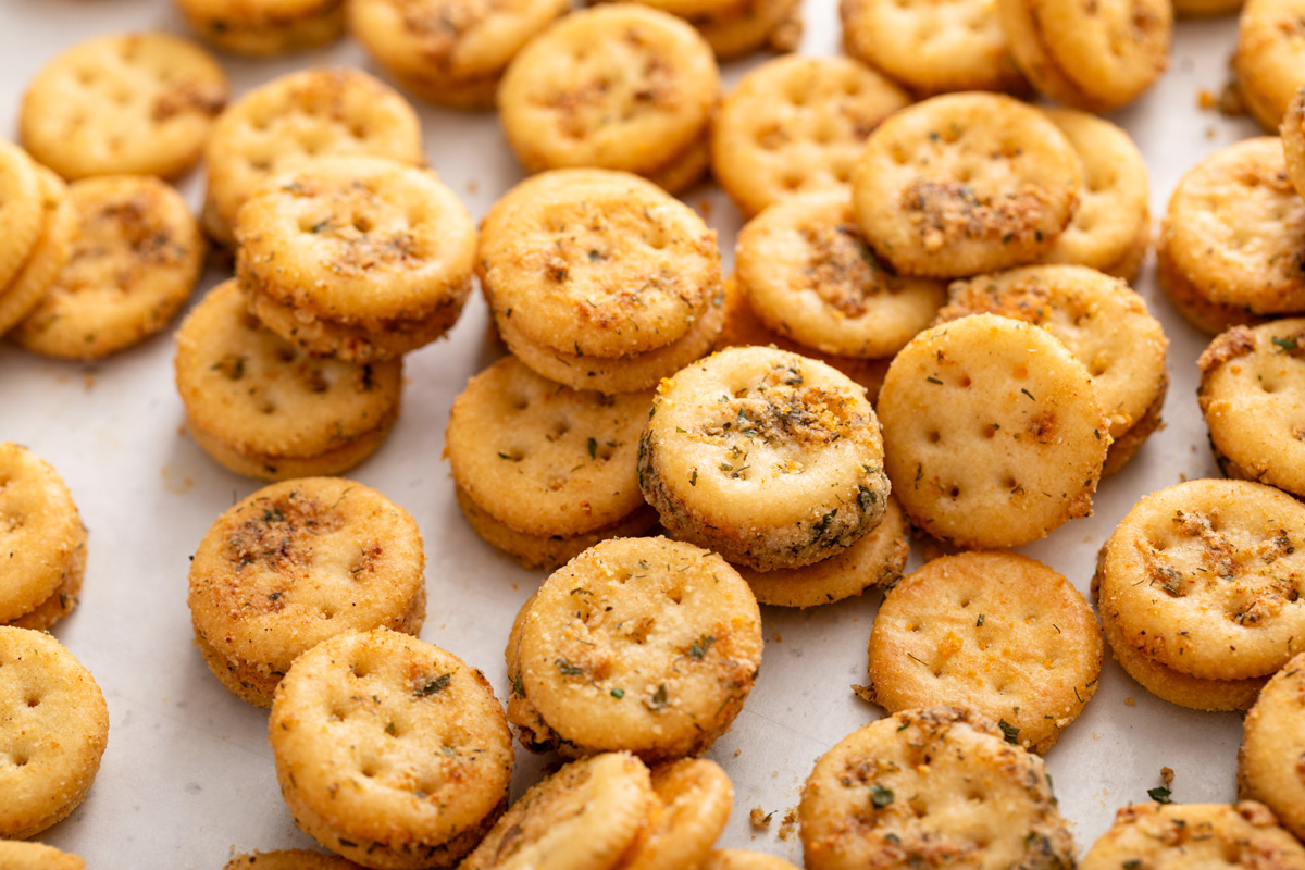 Close up photo of freshly baked ranch crackers on a piece of parchment paper.