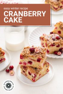 Two white plates of cranberry cake next to a glass of milk. Text overlay includes recipe name.