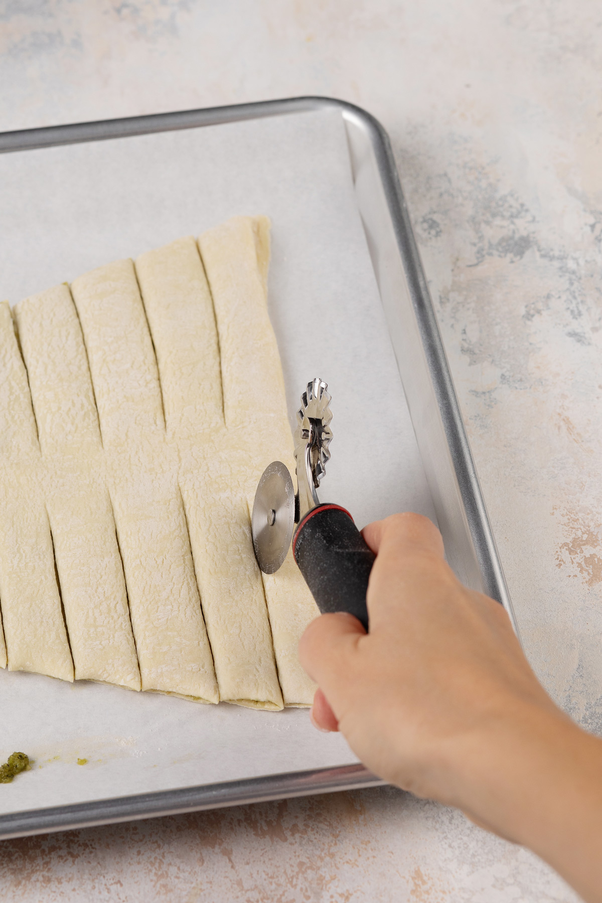 Strips being cut to create branches on a puff pastry christmas tree.