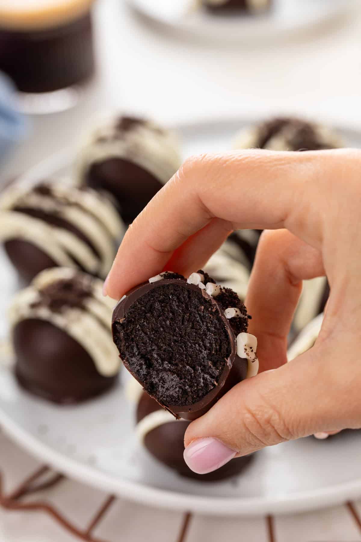 Hand holding up a halved oreo truffle.