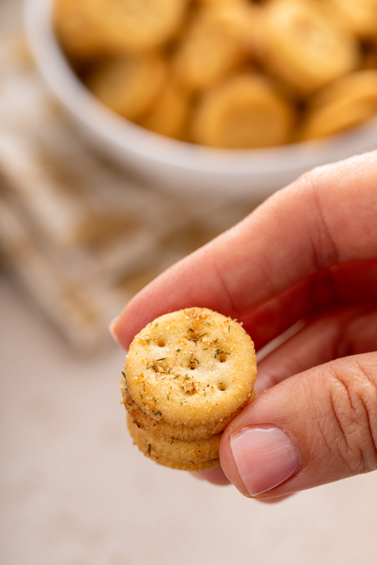 Hand holding up a couple of ranch crackers.