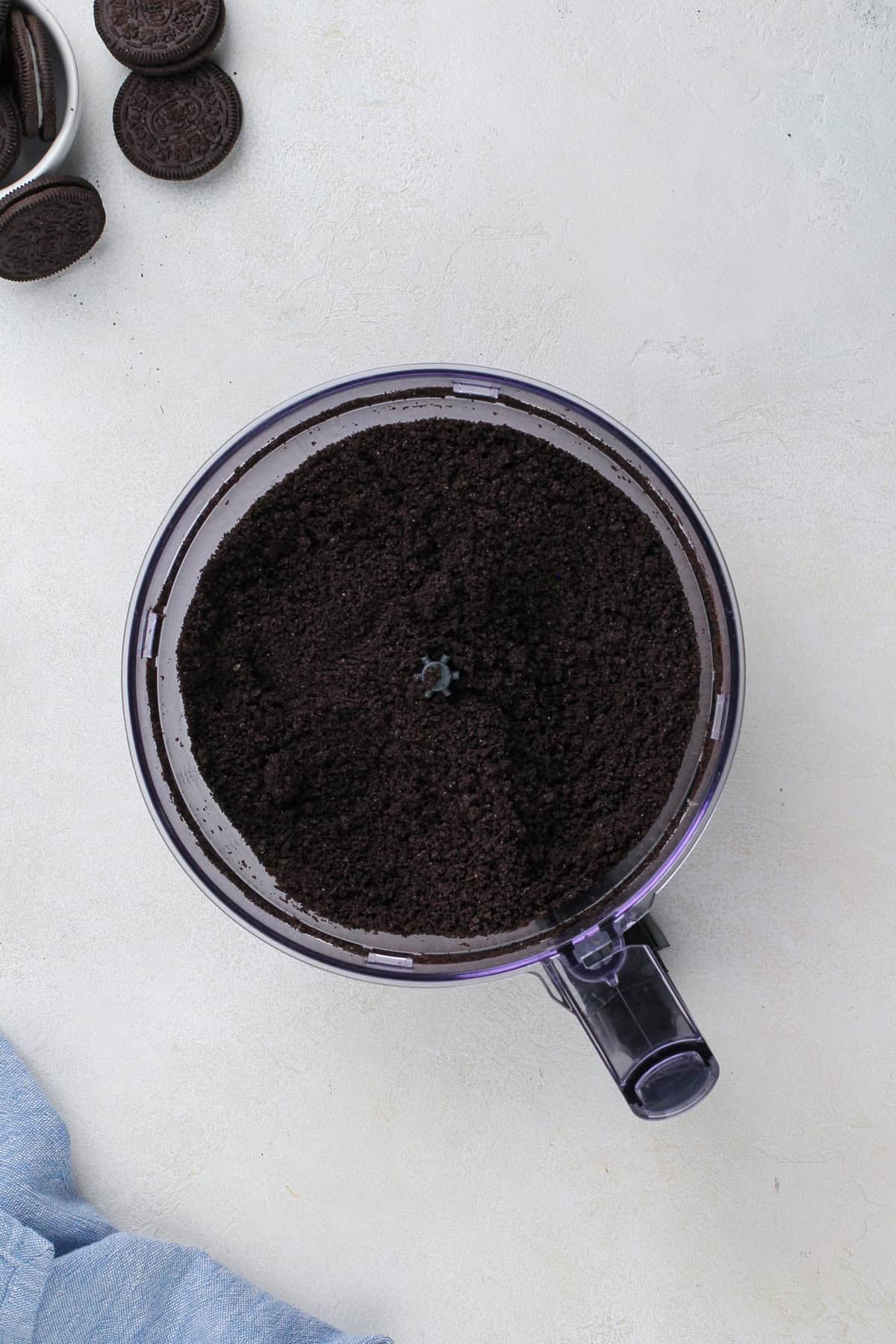 Oreo crumbs pulsed in the bowl of a food processor.