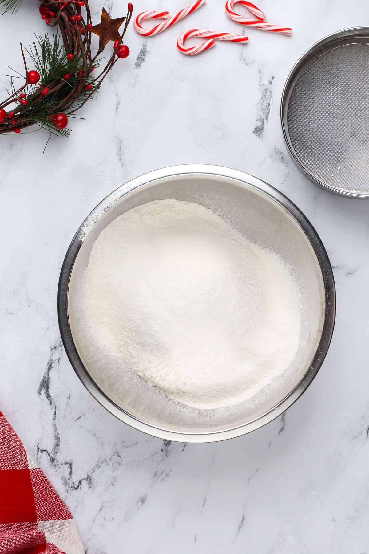 Dry ingredients for white chocolate peppermint cookies in a metal bowl.