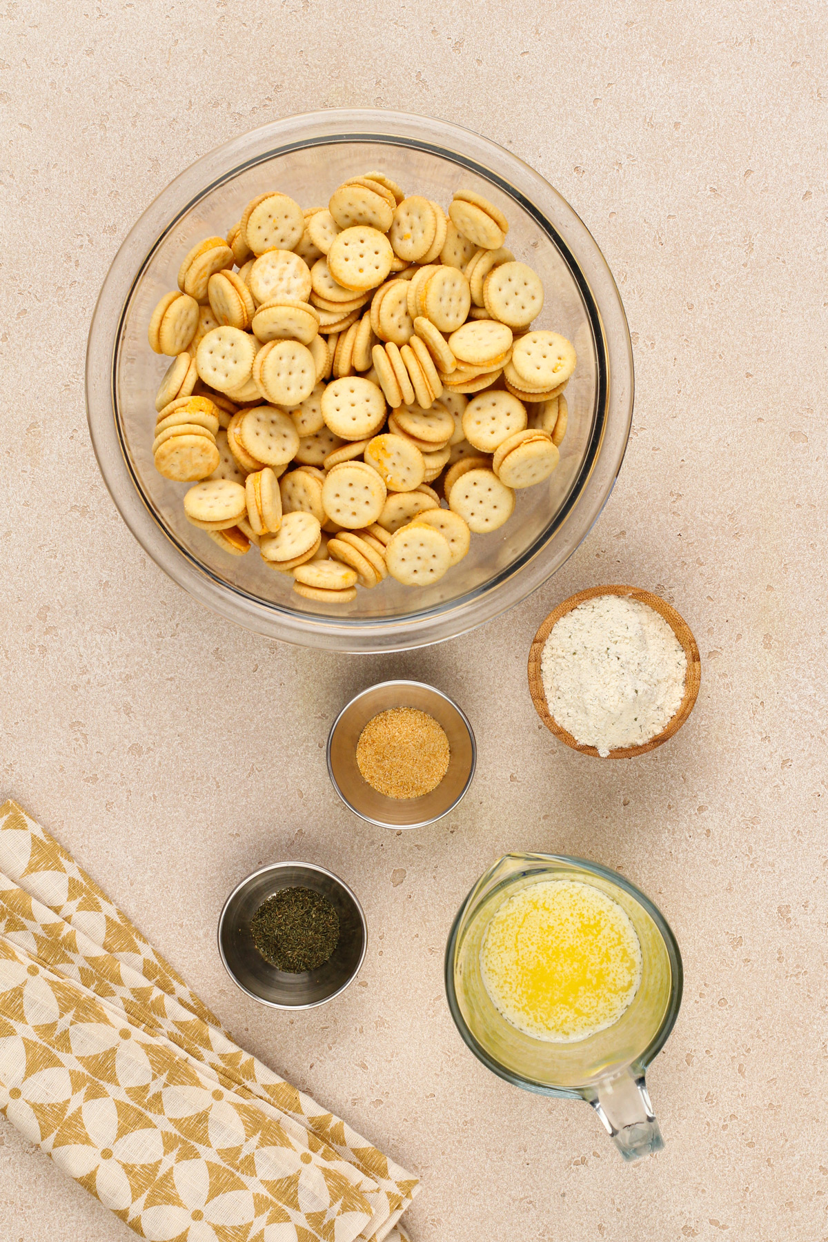 Ingredients for ranch crackers arranged on a beige countertop.