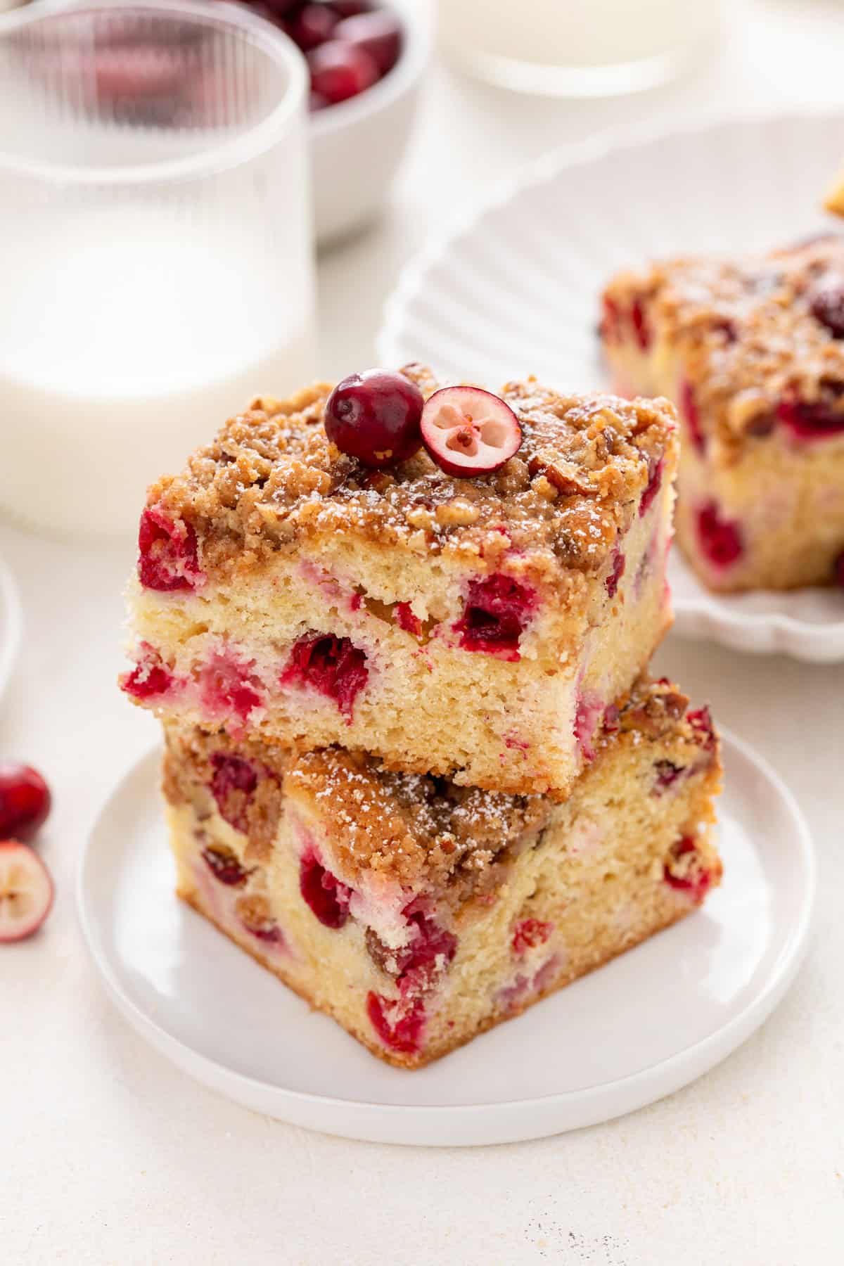 White plate holding two slices of stacked cranberry cake.