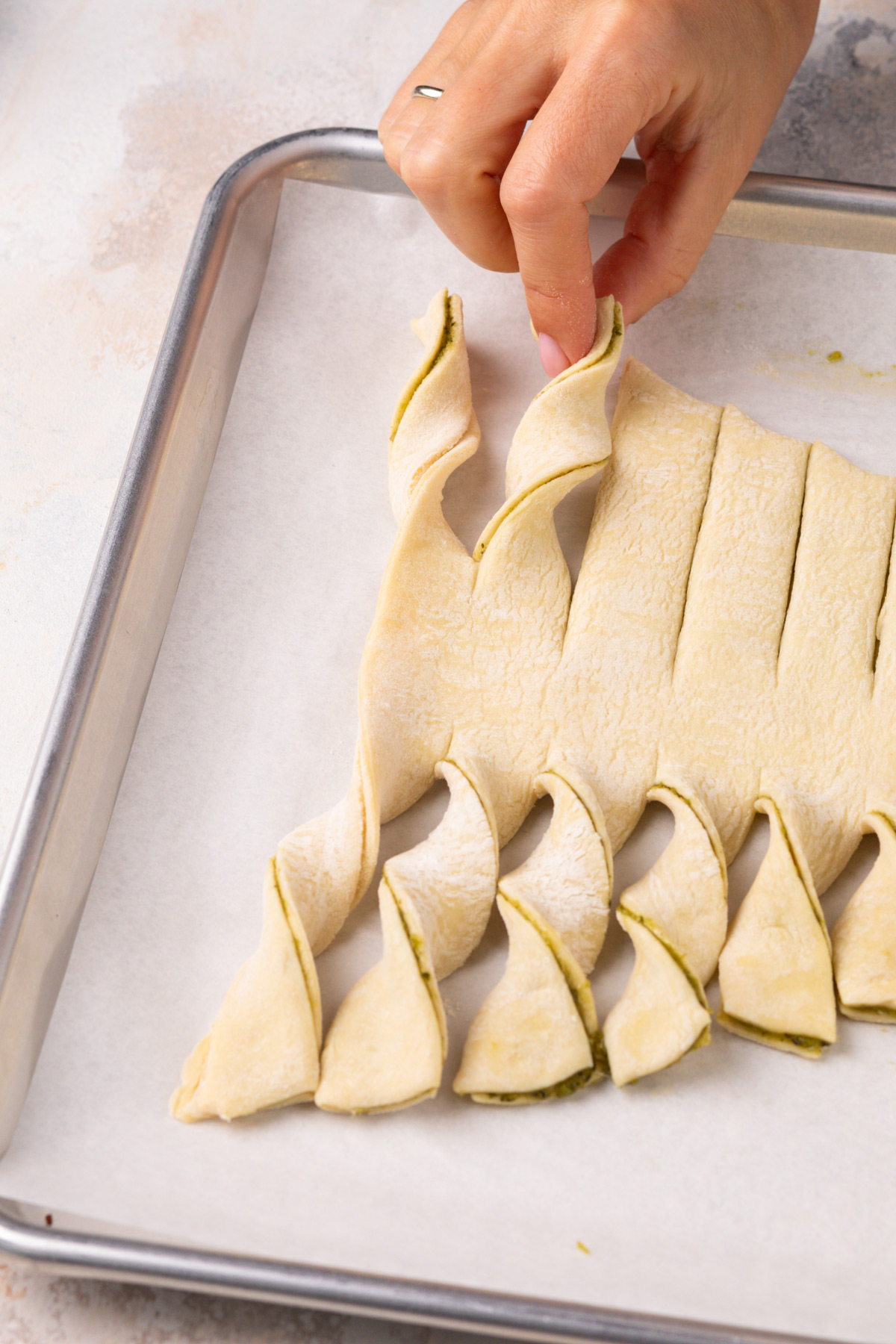 Hand twisting the "branches" on a puff pastry christmas tree.