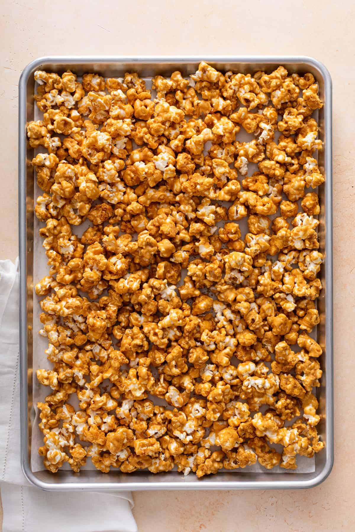 Baked caramel corn on a rimmed sheet tray.