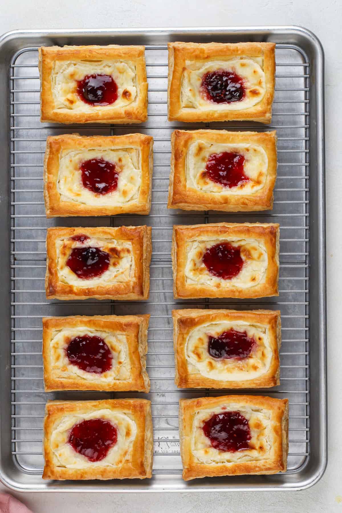 Baked puff pastry danishes cooling on a wire rack.