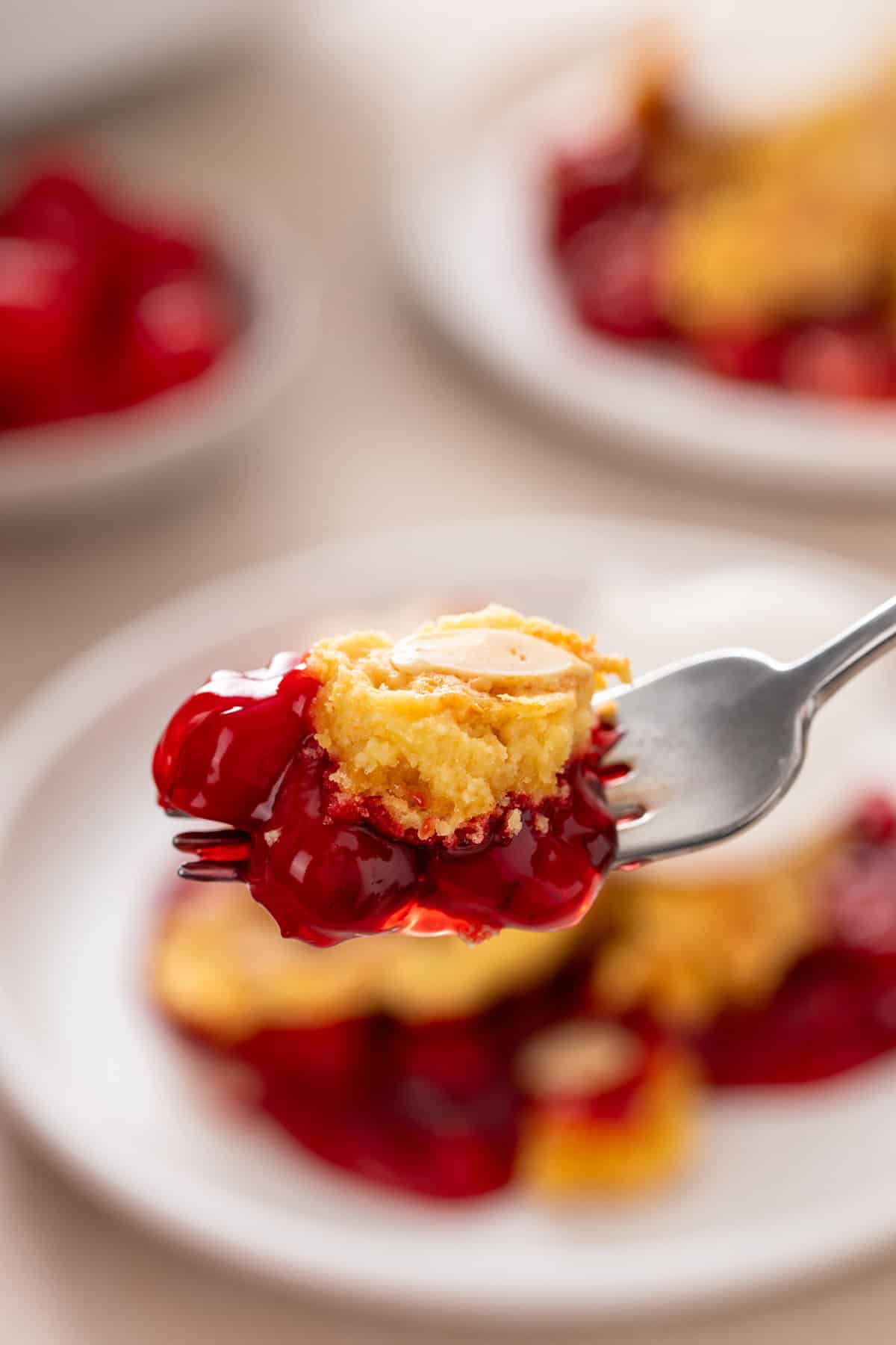 Bite of cherry dump cake on a fork.