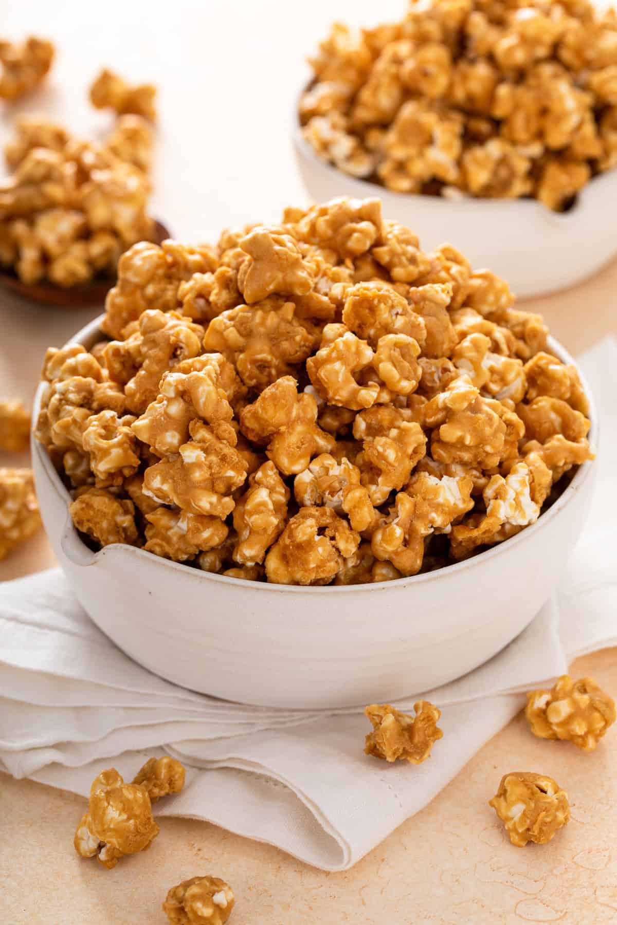 Caramel corn in white bowls set on a countertop.