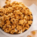 Close up image of caramel corn in a white bowl.