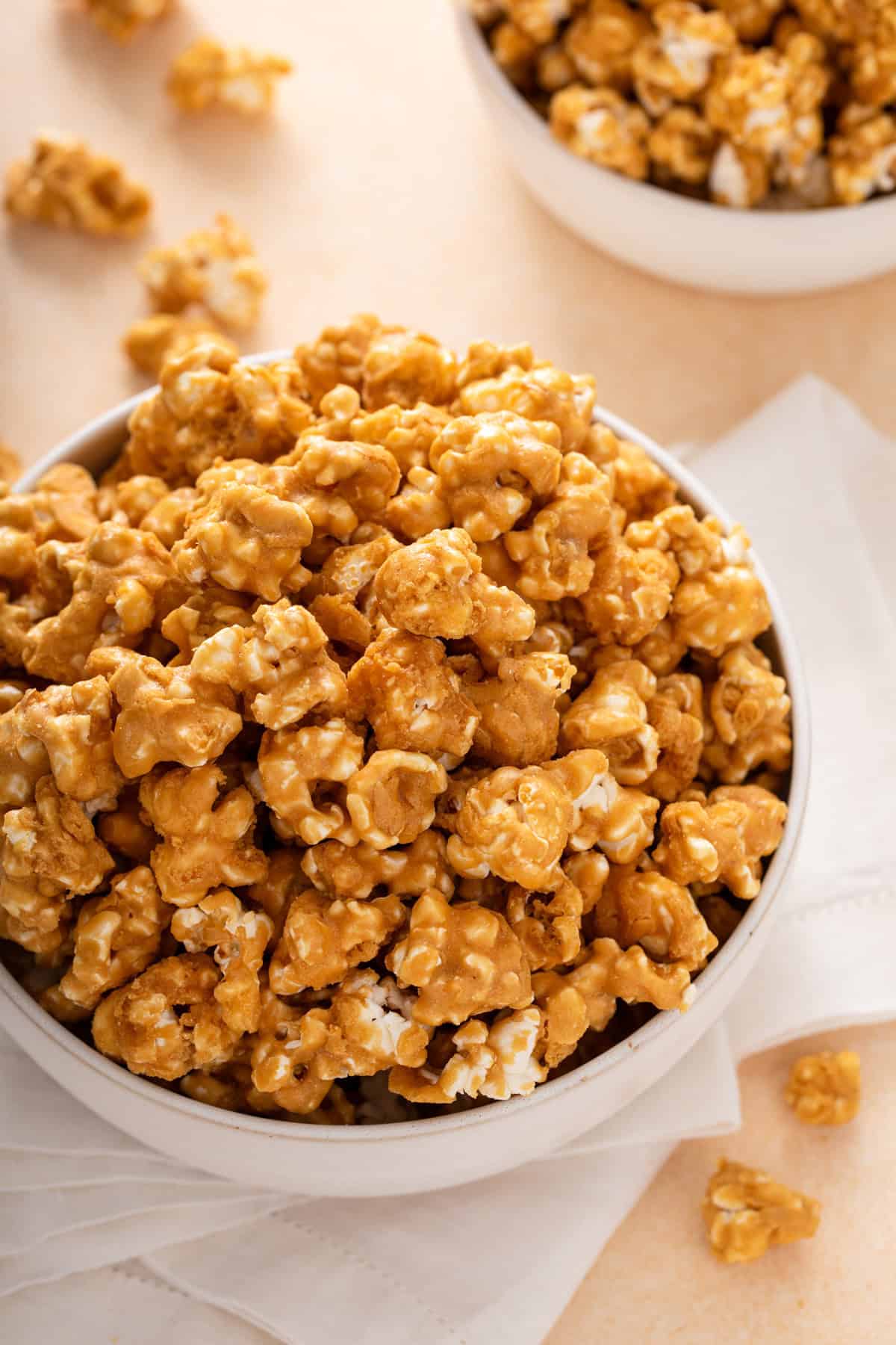 Close up of caramel corn piled in a white bowl.