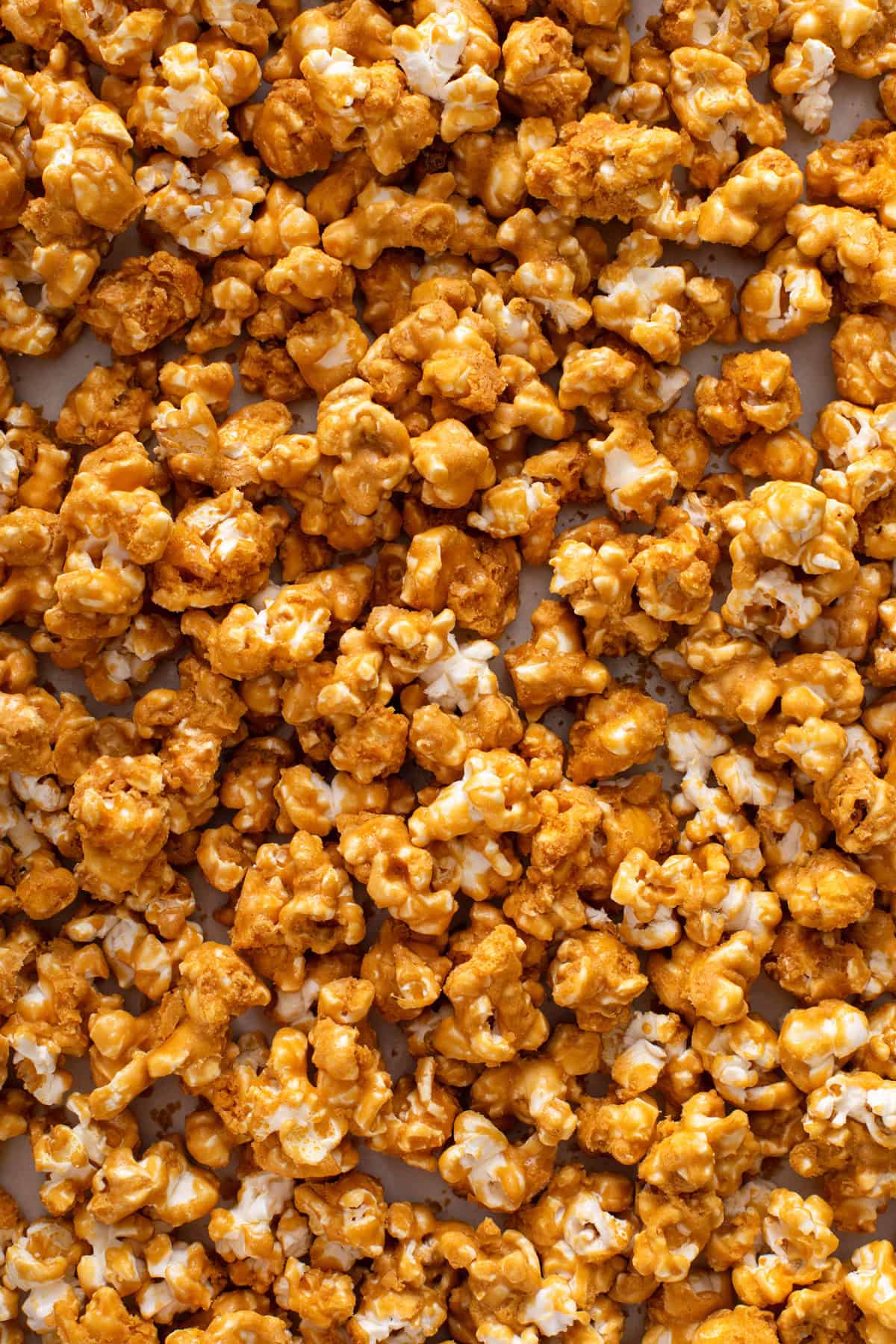 Close up image of homemade caramel corn spread on a baking sheet.