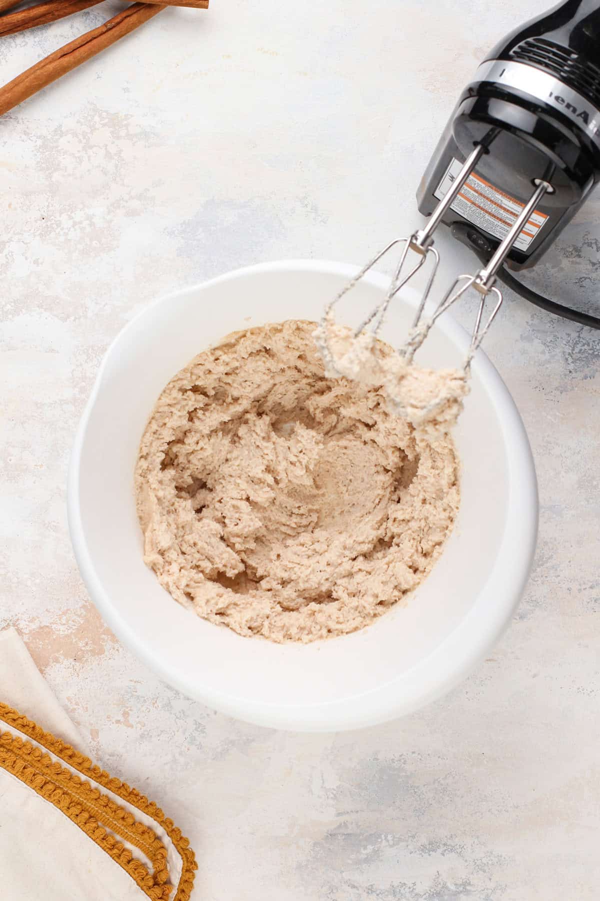 Brown butter and sugar creamed in a white bowl.