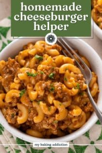 Close up view of a fork in a bowl of homemade cheeseburger helper. Text overlay includes recipe name.