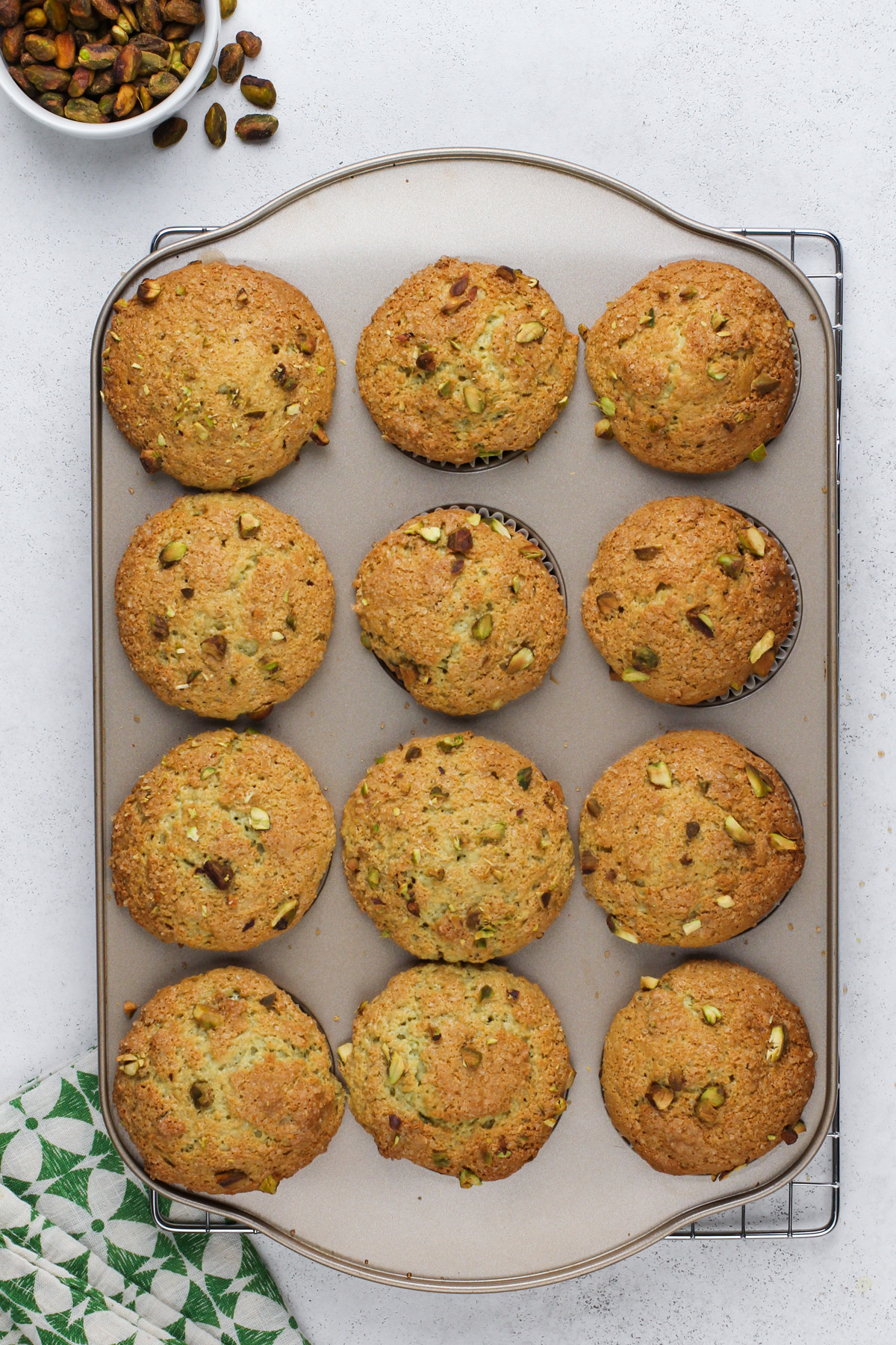 Overhead view of baked pistachio muffins in a muffin tin.