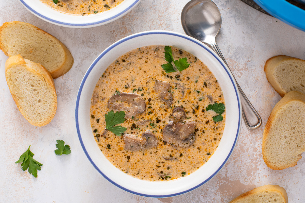 Overhead view of a white bowl filled with creamy mushroom soup.