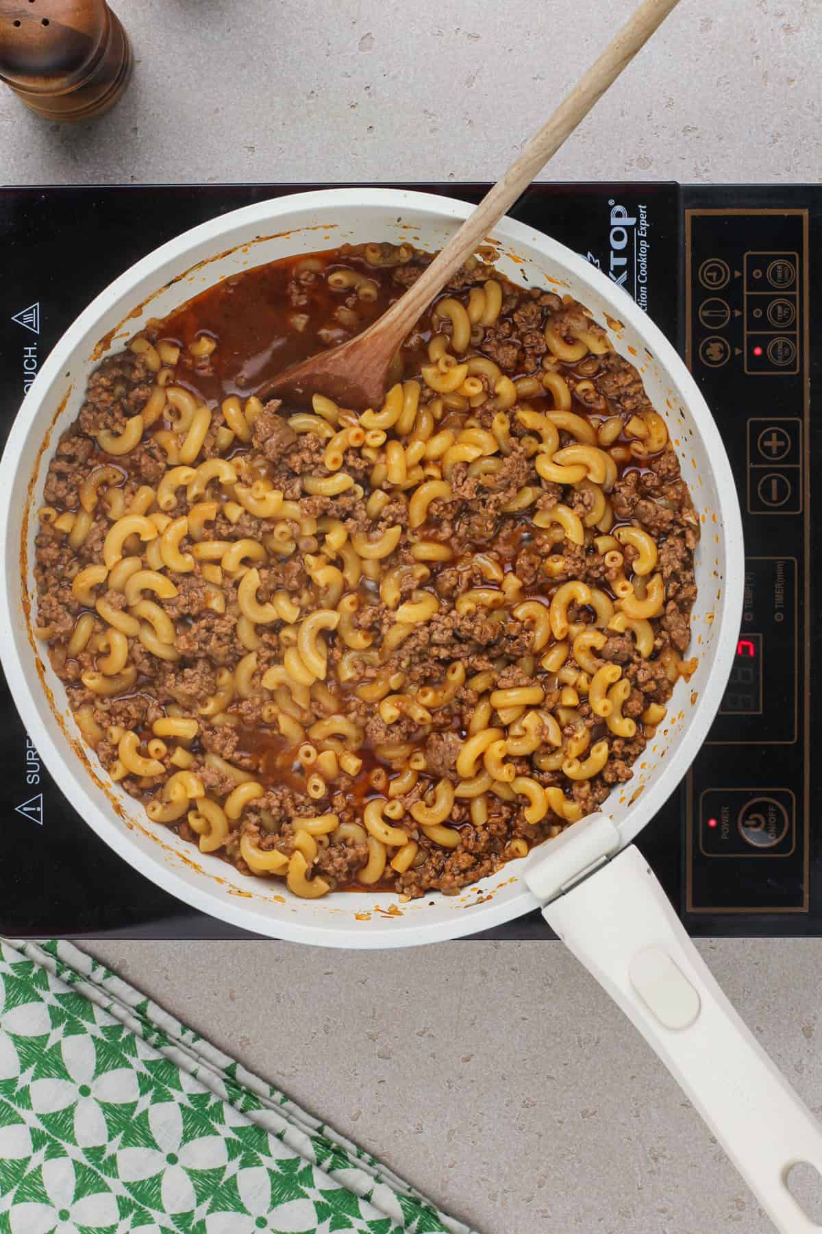 Cooked macaroni and ground beef in a skillet for hamburger helper.