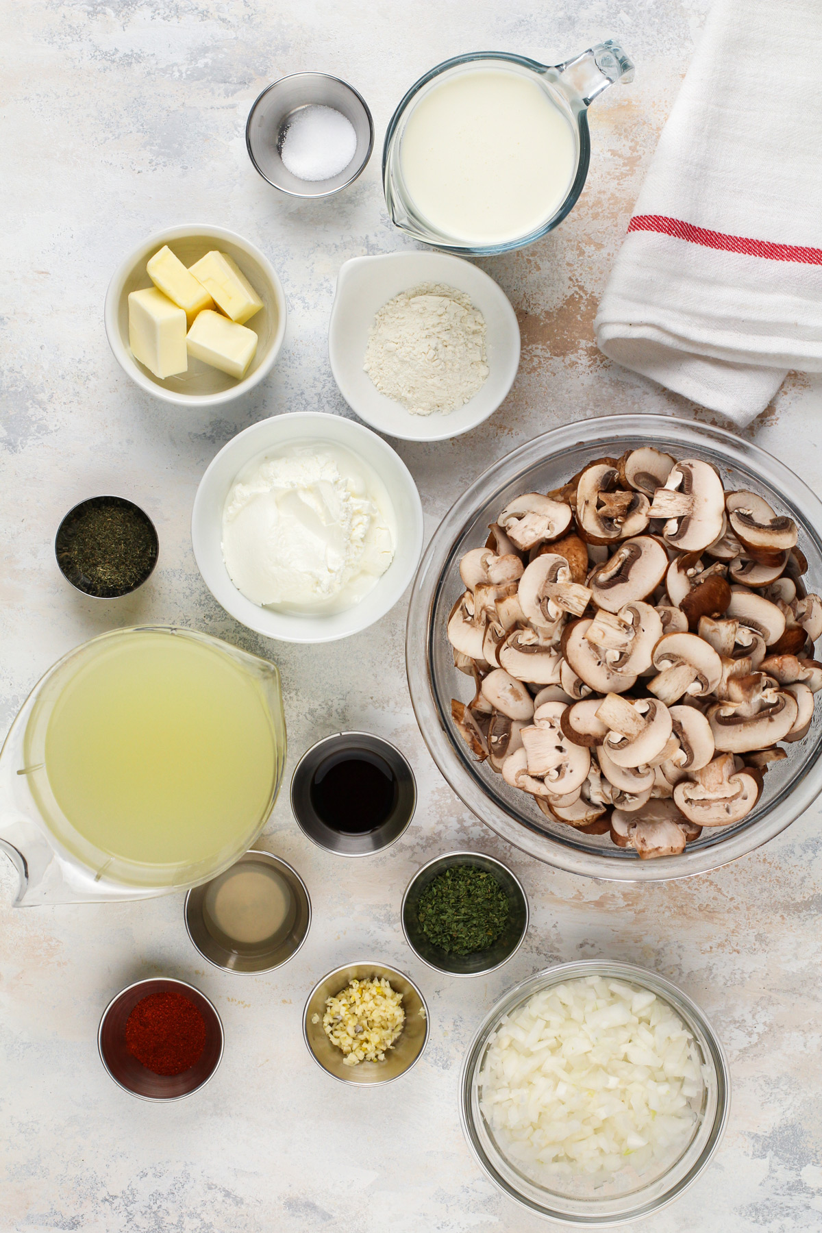 Ingredients for creamy mushroom soup arranged on a countertop.