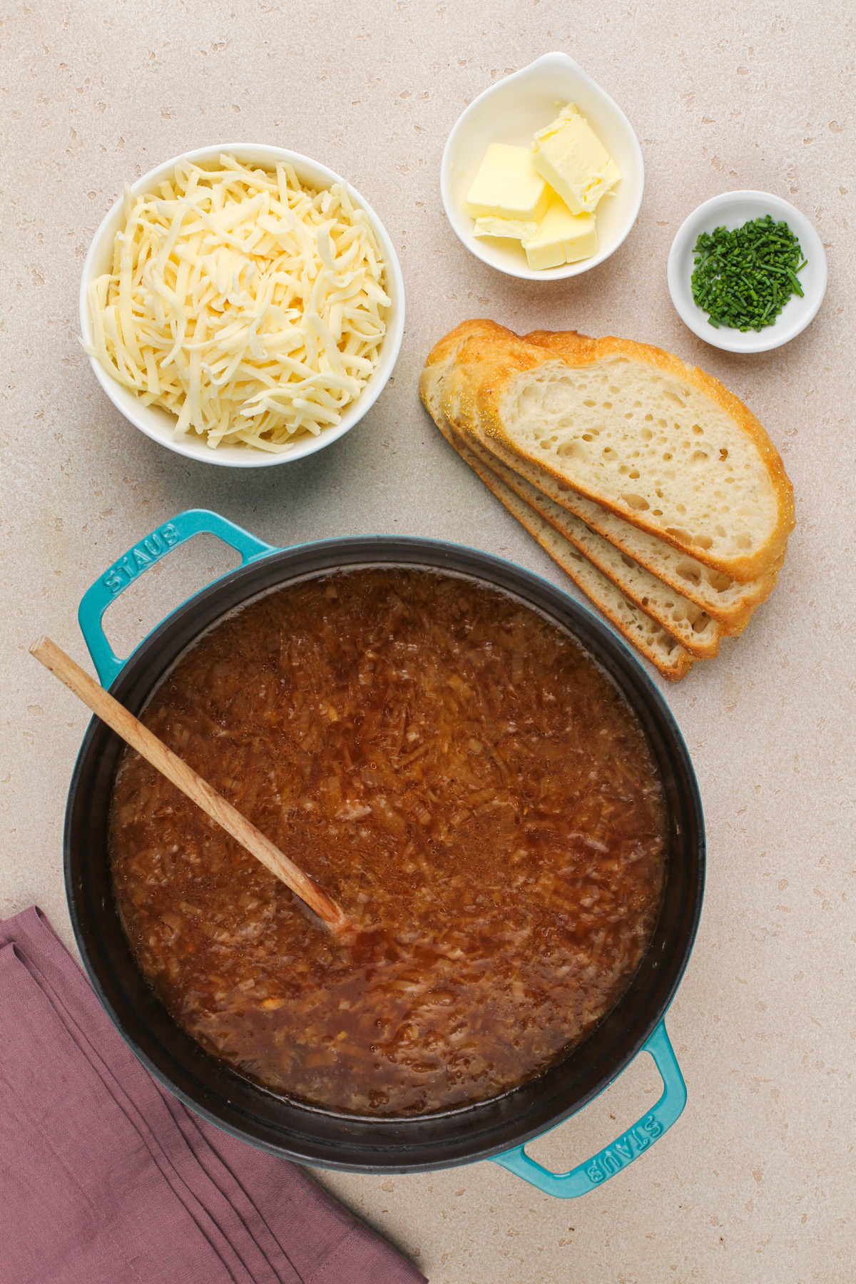 Ingredients for assembling and serving french onion soup arranged on a countertop.