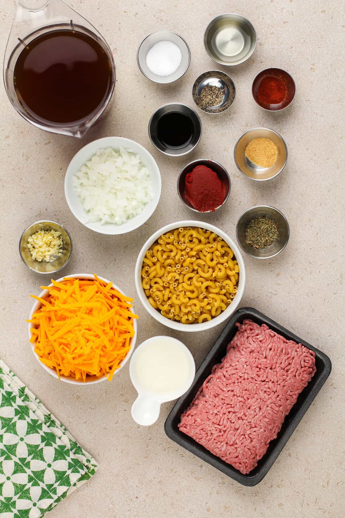 Ingredients for homemade cheeseburger helper arranged on a countertop.