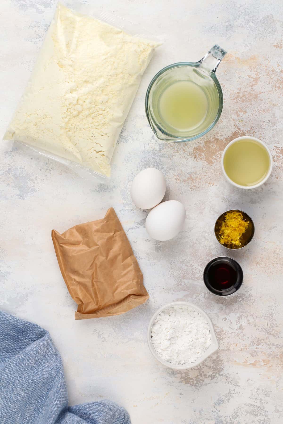 Lemon crinkle cookie ingredients arranged on a countertop.