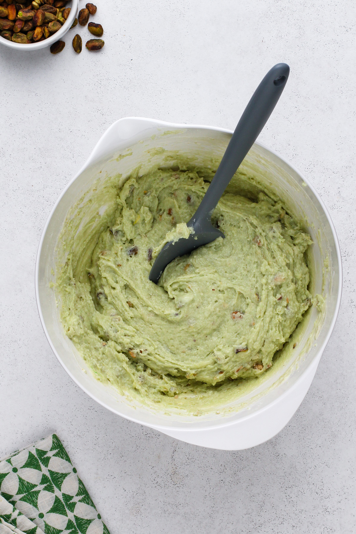 Pistachio muffin batter in a white bowl.